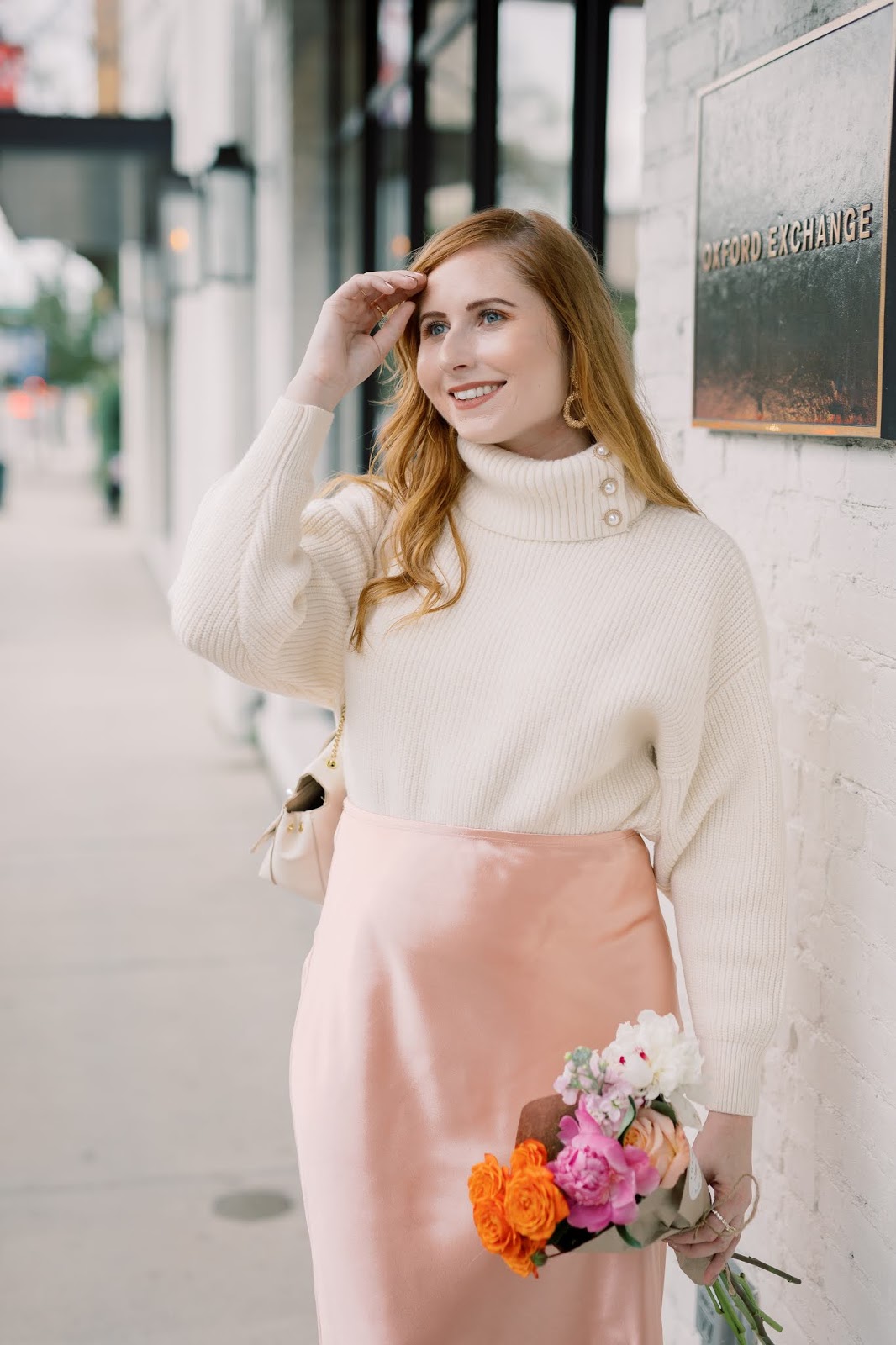 Where to Snag The Best Turtleneck Sweaters Under $50 | Style Blogger Amanda Burrows of Affordable by Amanda wears a cream chunky rib-knit turtleneck from H&M and a pink satin midi skirt from LC Lauren Conrads Kohl's collection at Oxford Exchange in Tampa, Florida. Photo taken by Studio Magnolia.