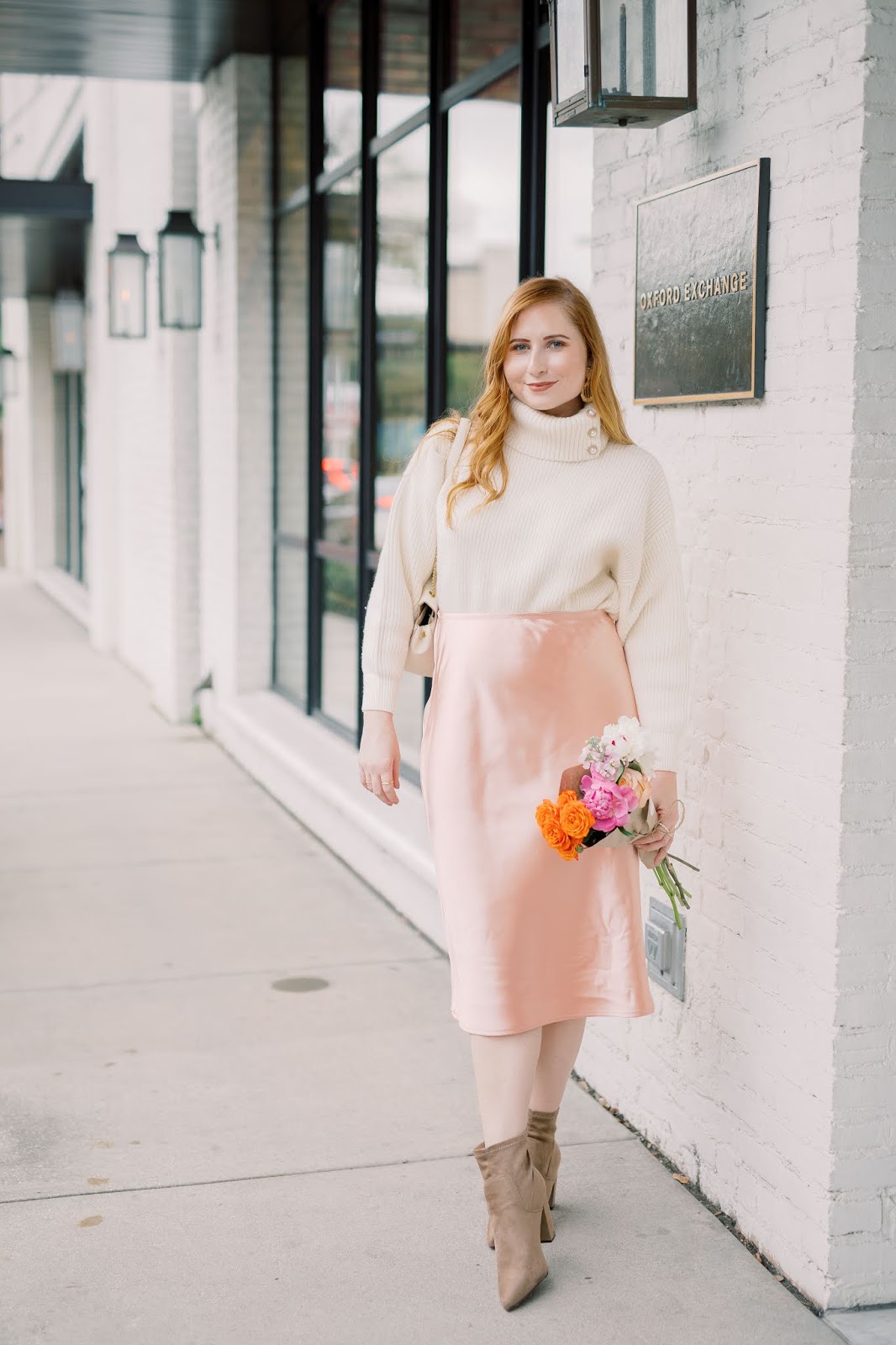 Where to Snag The Best Turtleneck Sweaters Under $50 | Style Blogger Amanda Burrows of Affordable by Amanda wears a cream chunky rib-knit turtleneck from H&M and a pink satin midi skirt from LC Lauren Conrads Kohl's collection at Oxford Exchange in Tampa, Florida. Photo taken by Studio Magnolia.