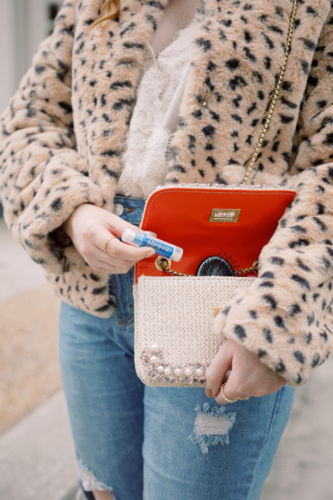 What's In My Winter Bag? Leopard faux fur jacket, ripped mom jeans, pearl purse. Amanda Burrows of Affordable by Amanda shares what's inside her winter bag with her essentials for on the go travel.