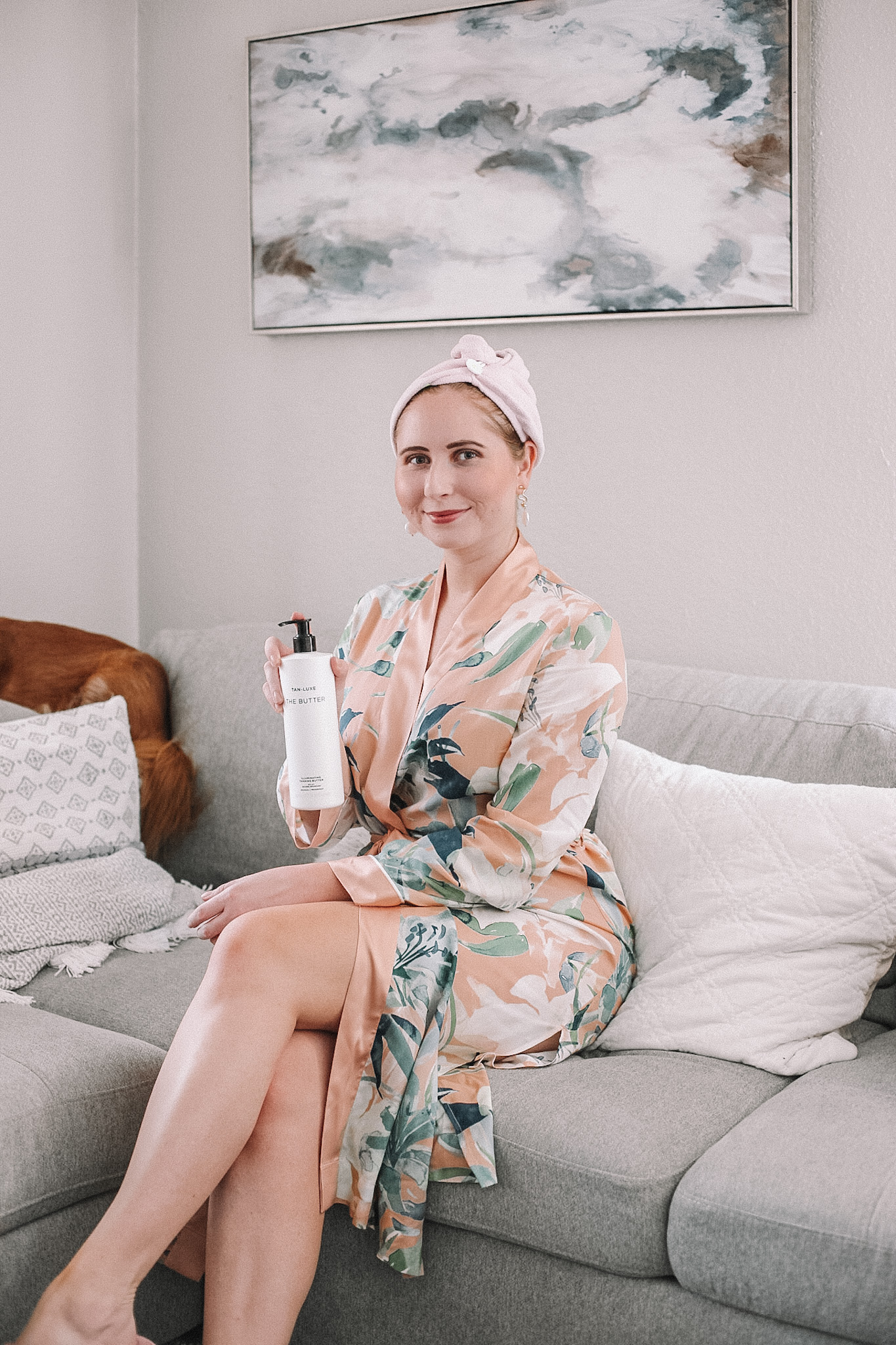 My Self Tanning Routine For Pale Skin | THE BUTTER Illuminating Tanning Butter | Tan-Luxe Product Review | THE BUTTER Illuminating Tanning Butter Review | Sephora Self Tanners For Pale Skin | Affordable by Amanda shares her self-tanning routine for pale skin wearing a floral robe sitting on a gray couch.