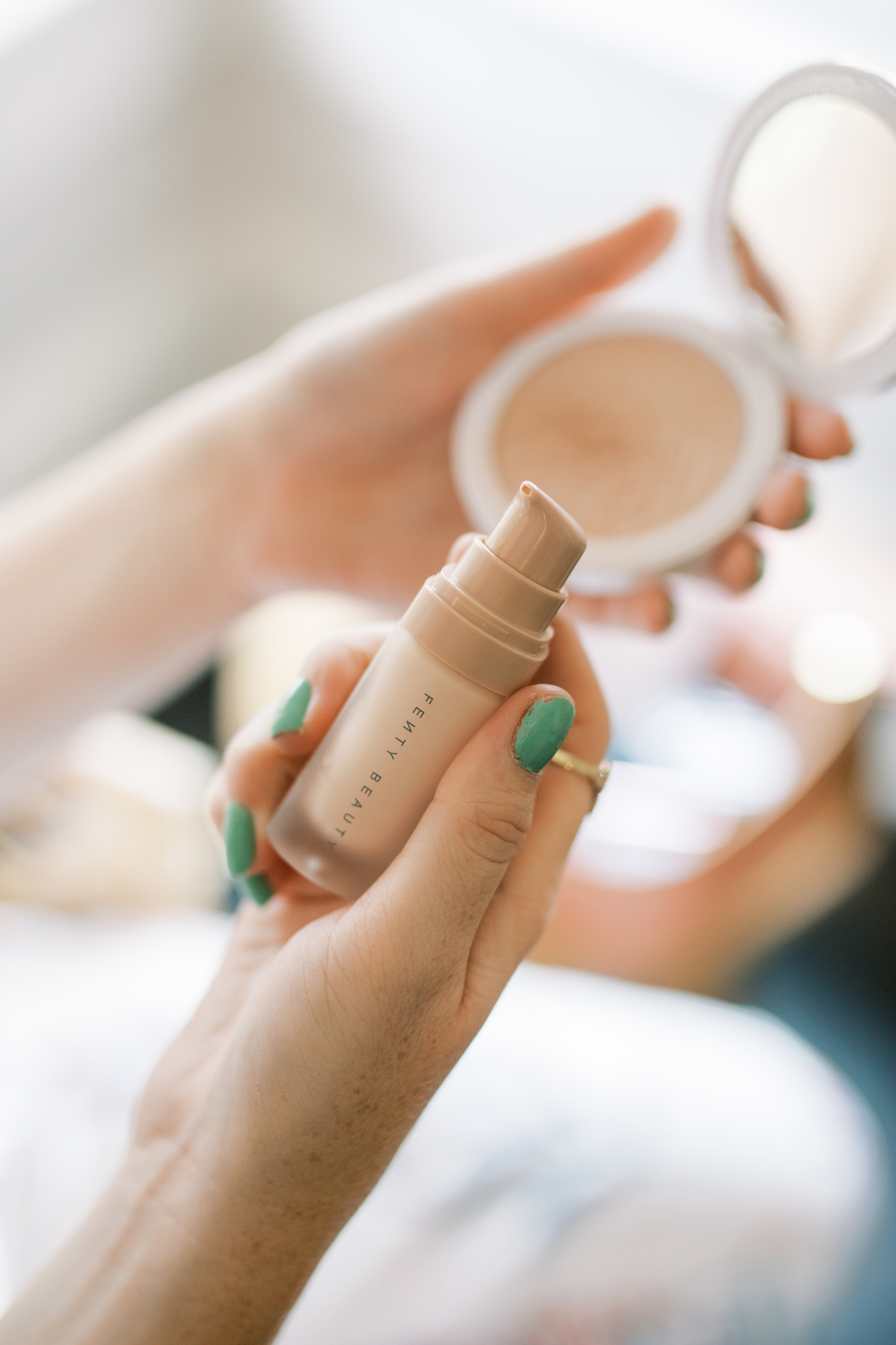 Amanda Burrows of the blog Affordable by Amanda holds up Fenty Beauty Pro Filt'r Instant Retouch Primer in her hand. 
