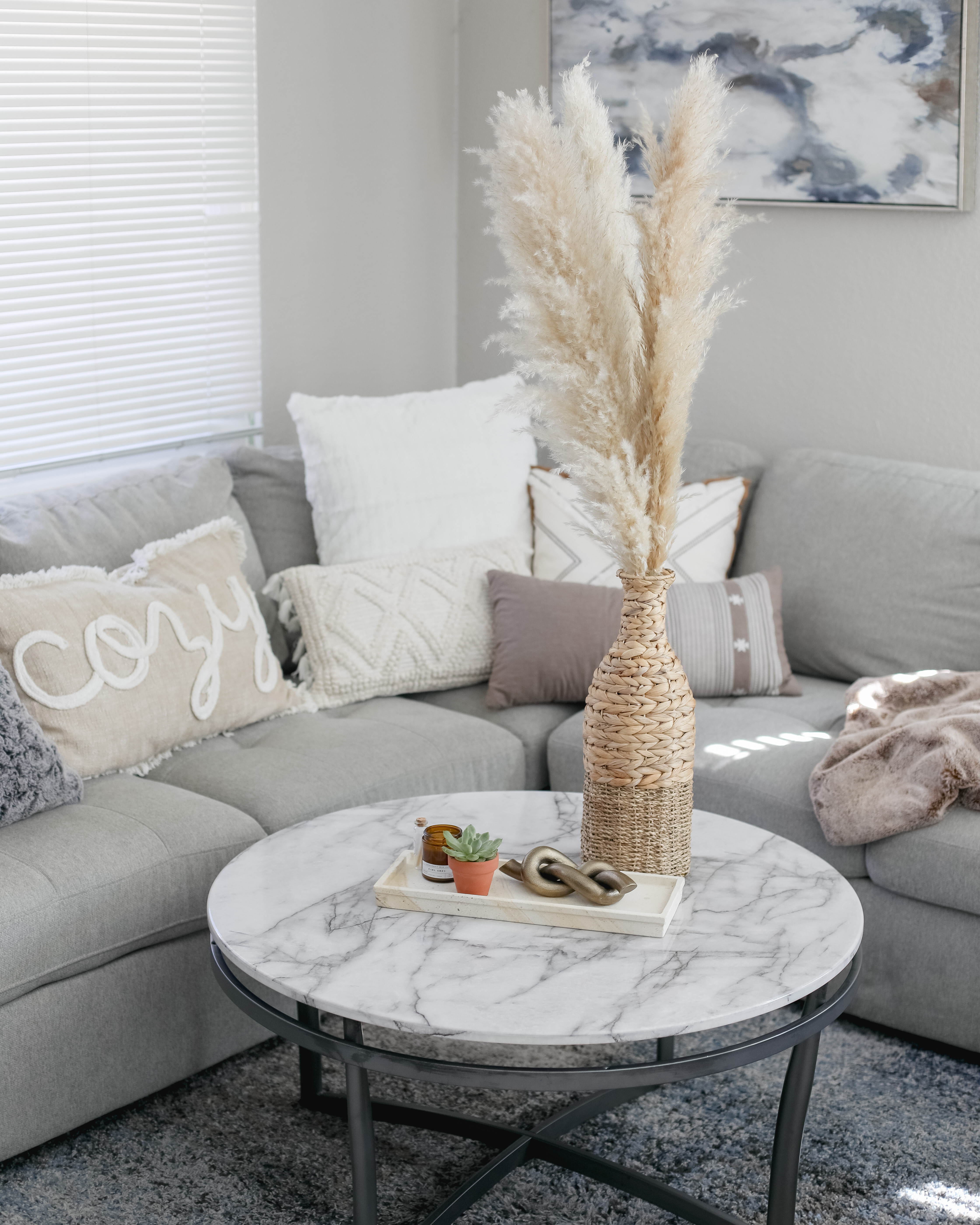https://affordablebyamanda.com/wp-content/uploads/2021/02/Target-Modern-Spring-Decor-gray-couch-neutral-white-gray-throw-pillows-rattan-braided-basket-vase.JPG.jpg
