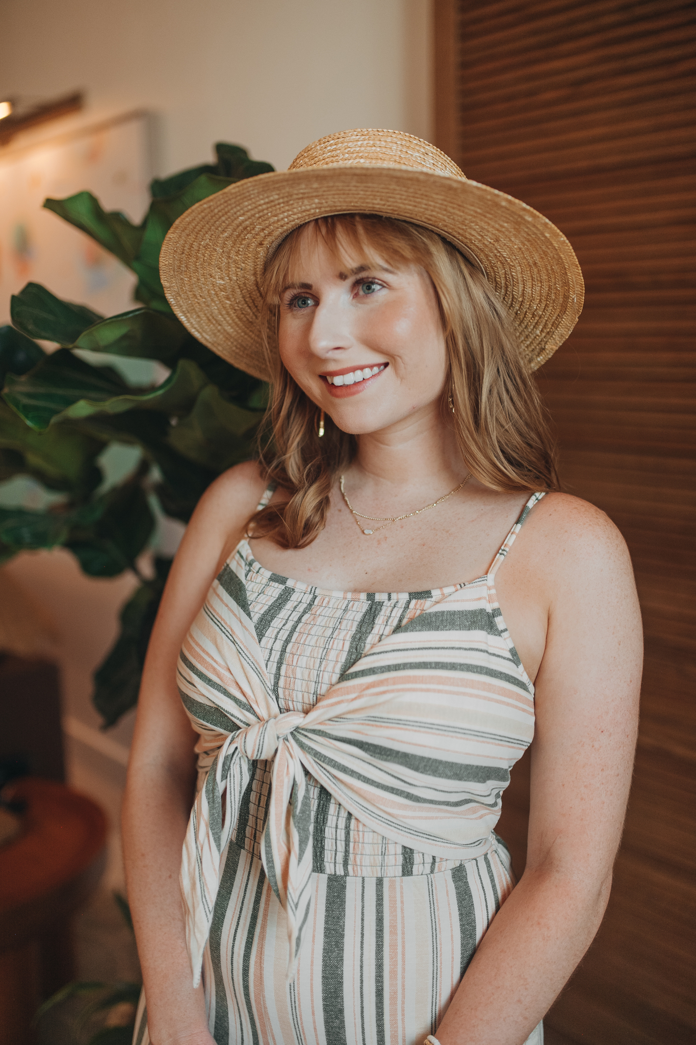 Born This Way Undetectable Medium-to-Full Coverage Foundation - Affordable by Amanda shares her top picks for high end makeup products that are worth the splurge. Amanda Burrows wears a straw hat, green and pink striped jumpsuit.