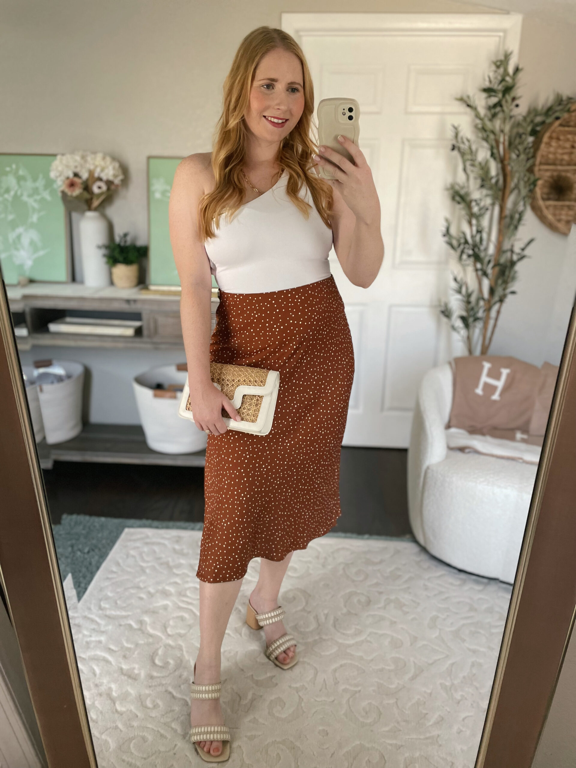 White bodysuit, brown polka dot midi skirt, neutral block heels, rattan purse